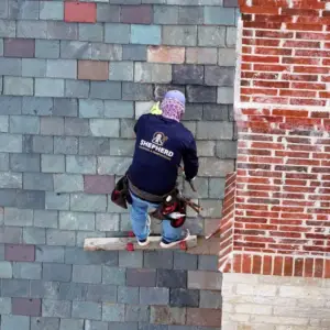Shepherd roofing employee replacing slate tile