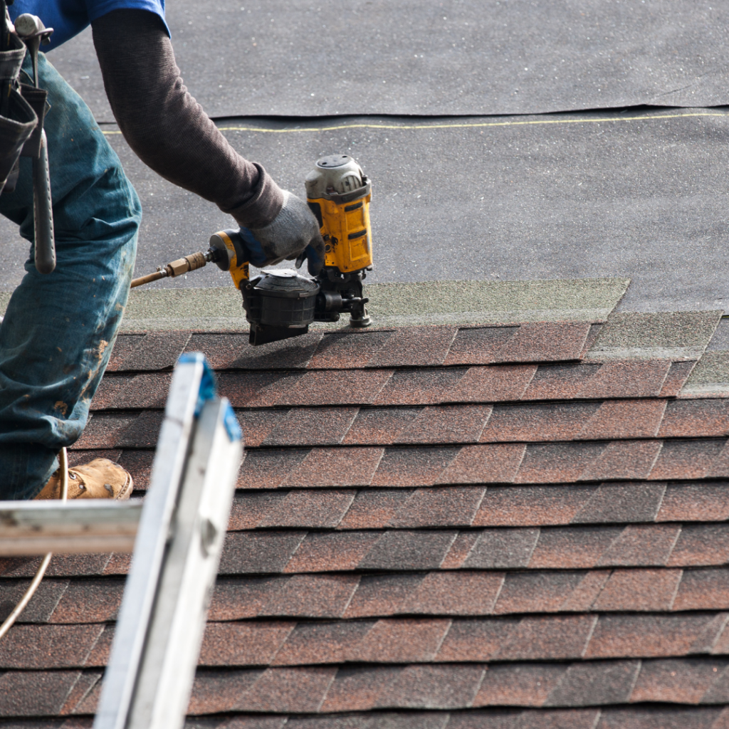 image of a person using a nail gun installing shingles