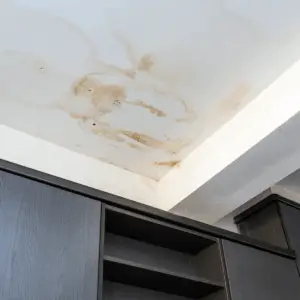 Leaking residential roof in Dallas with visible water stain
