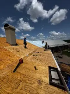 Sandstone-colored snap lock metal roof panels being installed in Texas
