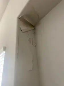 Interior water damage on wall caused by roof leak from incorrect shingle installation